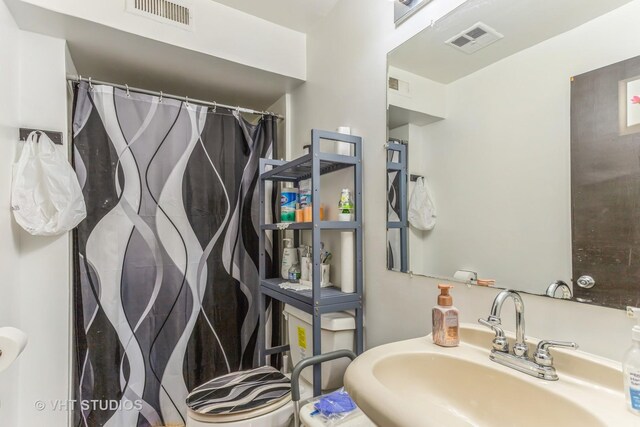 bathroom with visible vents, a sink, and a shower with curtain