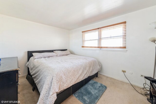 bedroom featuring baseboards and light carpet