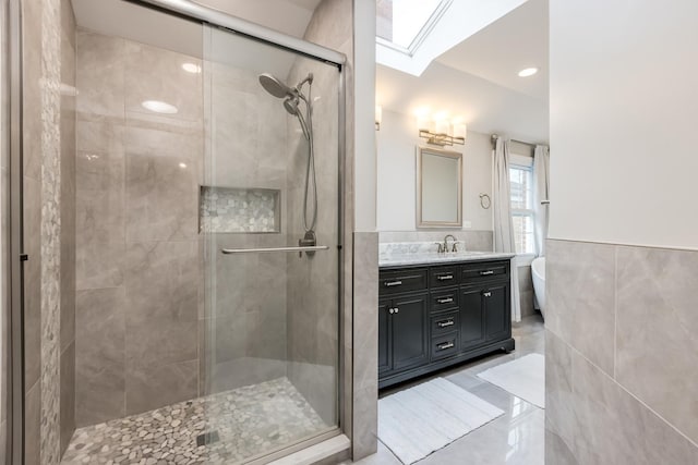 6700 N Monticello Ave, Lincolnwood, IL 60712 - bathroom featuring wainscoting, vanity, tile walls, a shower stall, and a skylight