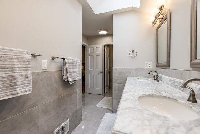 6700 N Monticello Ave, Lincolnwood, IL 60712 - bathroom with visible vents, a sink, wainscoting, and tile walls