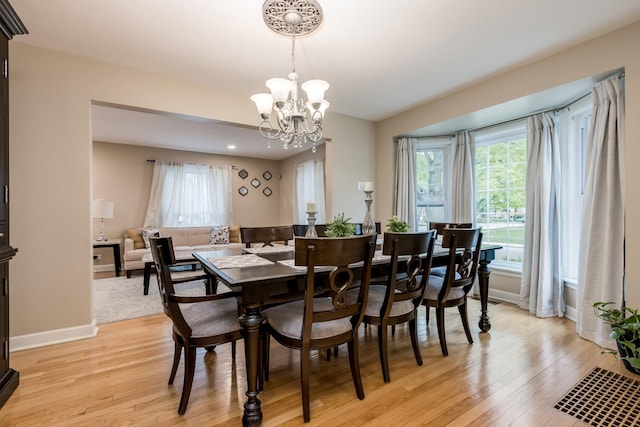 6700 N Monticello Ave, Lincolnwood, IL 60712 - dining room with light wood-type flooring, baseboards, a notable chandelier, and a wealth of natural light