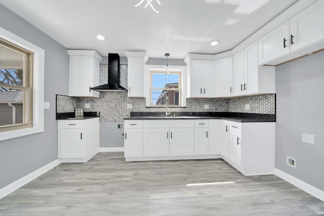 7315 S California Ave, Chicago, IL 60629 - kitchen with dark countertops, baseboards, wall chimney range hood, white cabinets, and backsplash