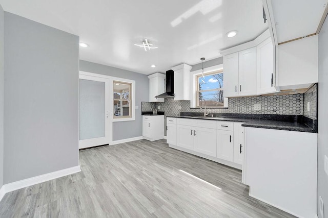 7315 S California Ave, Chicago, IL 60629 - kitchen with backsplash, dark countertops, white cabinetry, baseboards, and wall chimney exhaust hood