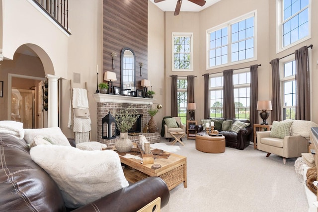 7659 Fairway Dr, Yorkville, IL 60560 - carpeted living area featuring ceiling fan, decorative columns, a towering ceiling, arched walkways, and a fireplace