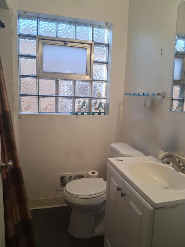 full bathroom featuring toilet, visible vents, a wealth of natural light, and vanity