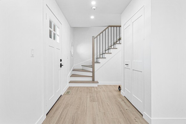 foyer entrance featuring stairs, light wood-style floors, baseboards, and recessed lighting