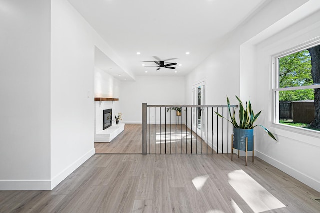 corridor featuring wood finished floors, baseboards, and recessed lighting