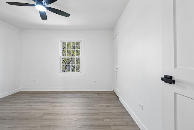 unfurnished room with ceiling fan, light wood-type flooring, and baseboards