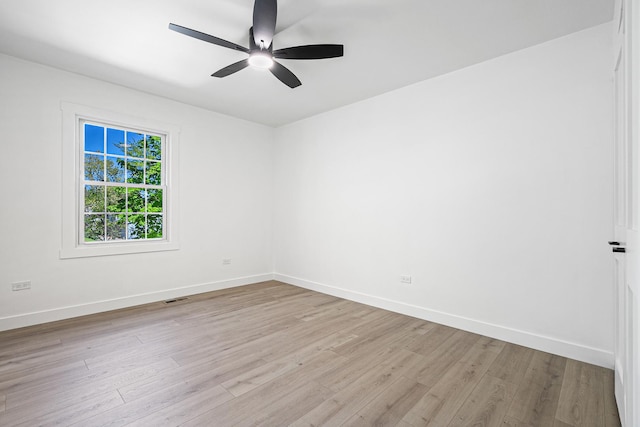 spare room featuring baseboards, light wood-style floors, and ceiling fan
