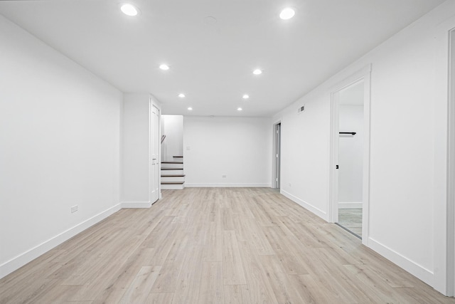 empty room featuring recessed lighting, stairs, light wood-style floors, and baseboards