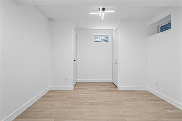 basement featuring light wood-type flooring and baseboards