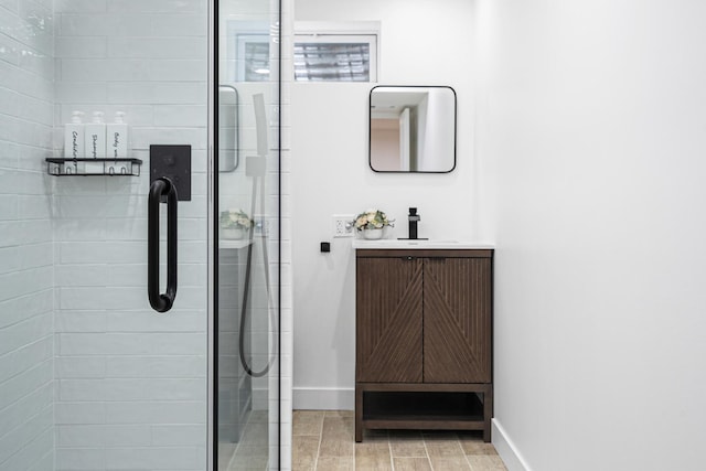 full bathroom featuring baseboards, a shower stall, and vanity
