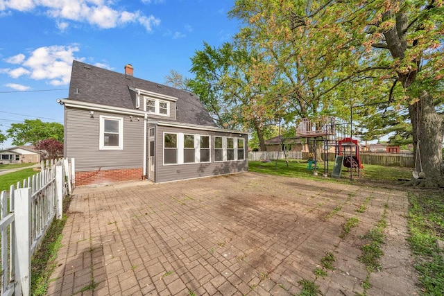 12540 S Tripp Ave, Alsip, IL 60803 - back of property with a playground, a patio area, a fenced backyard, a chimney, and roof with shingles