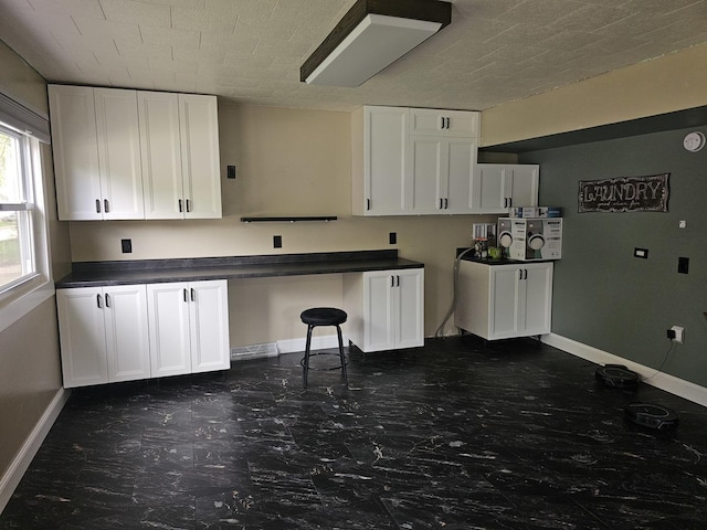 1208 Minkel St, Rock Falls, IL 61071 - kitchen with white cabinetry, baseboards, dark countertops, and built in study area