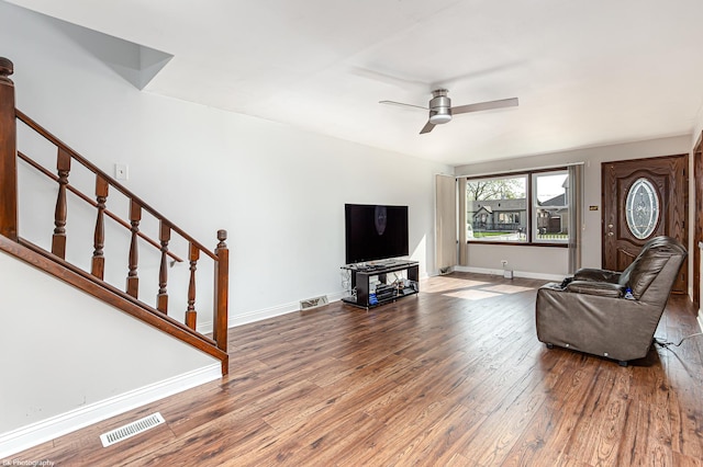 living room featuring stairway, a ceiling fan, wood finished floors, and visible vents