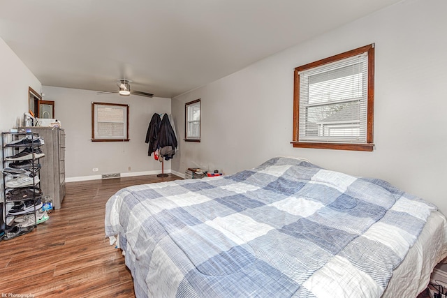 bedroom featuring baseboards, a ceiling fan, wood finished floors, and visible vents