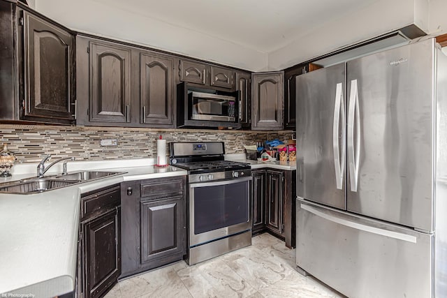 kitchen with dark brown cabinets, a sink, light countertops, marble finish floor, and stainless steel appliances