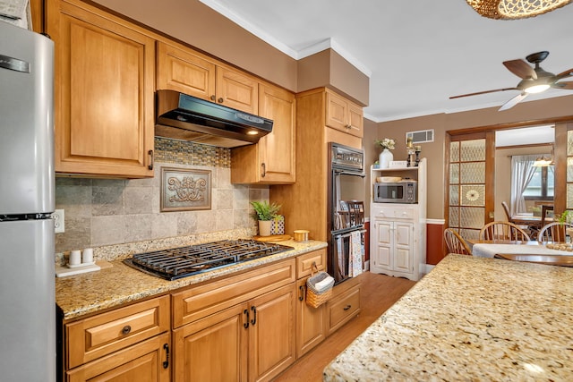 kitchen featuring black appliances, visible vents, light wood-type flooring, under cabinet range hood, and ceiling fan