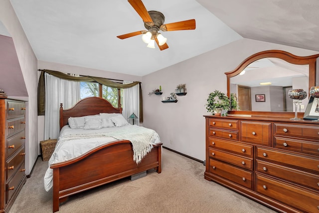 bedroom featuring vaulted ceiling, light carpet, baseboards, and a ceiling fan
