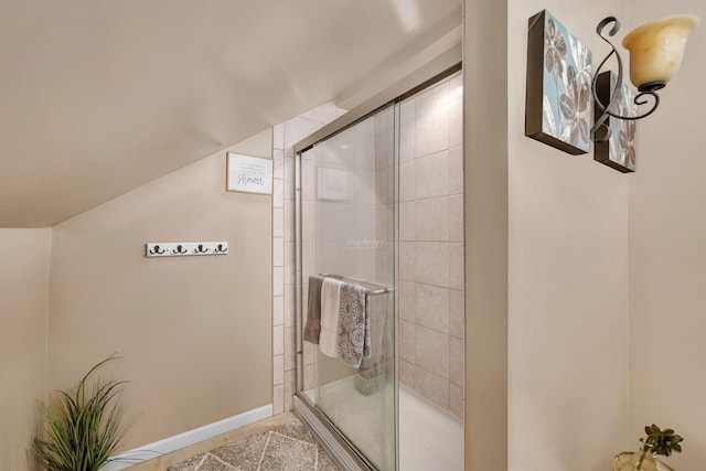 bathroom featuring a shower stall, lofted ceiling, and tile patterned floors