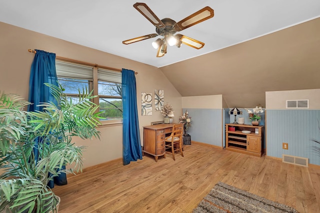 office space featuring lofted ceiling, ceiling fan, visible vents, and wood finished floors