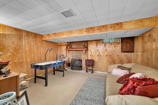 playroom featuring wooden walls and a brick fireplace