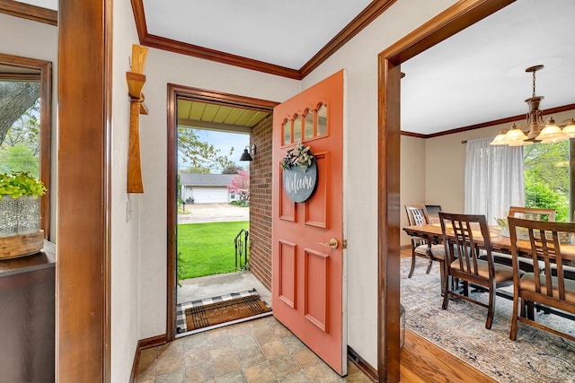 entrance foyer featuring an inviting chandelier, baseboards, stone finish flooring, and crown molding