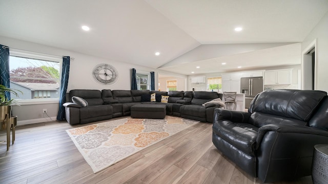 living room featuring light wood finished floors, vaulted ceiling, and recessed lighting