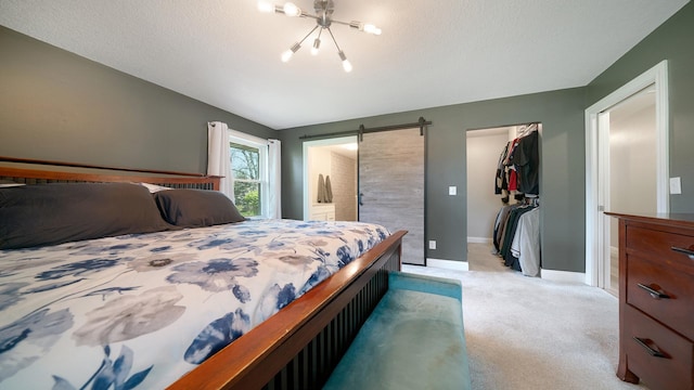 bedroom featuring a closet, light colored carpet, an inviting chandelier, a spacious closet, and baseboards