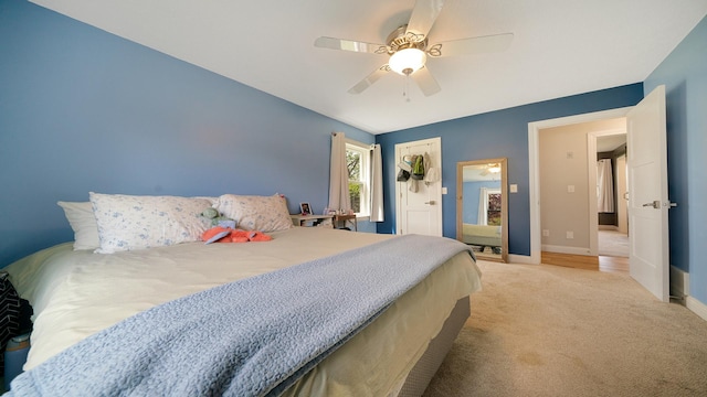 bedroom with baseboards, ceiling fan, and light colored carpet