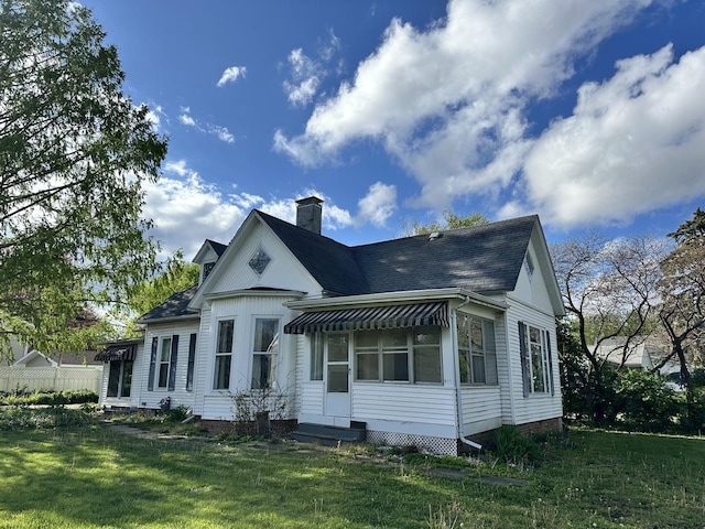 503 N William St, Farmer City, IL 61842 - rear view of property with a shingled roof, a yard, and a chimney