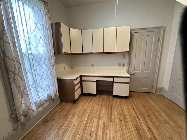 503 N William St, Farmer City, IL 61842 - kitchen with built in study area, light countertops, light wood-style flooring, and white cabinetry