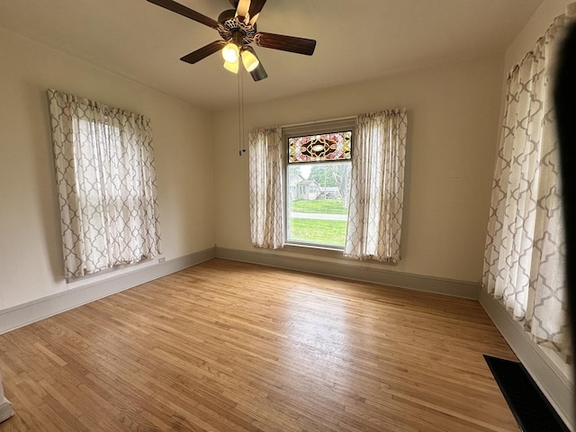 503 N William St, Farmer City, IL 61842 - unfurnished room with baseboards, a ceiling fan, and light wood-style flooring