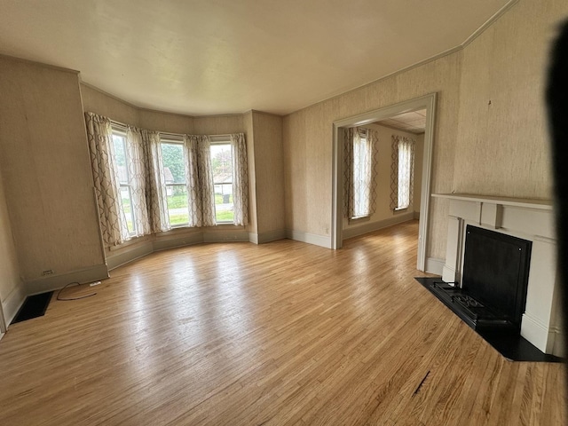 503 N William St, Farmer City, IL 61842 - unfurnished living room with a fireplace with flush hearth, baseboards, light wood-style floors, and visible vents