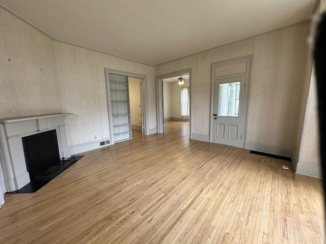 503 N William St, Farmer City, IL 61842 - unfurnished living room with ceiling fan, visible vents, a fireplace with flush hearth, wood finished floors, and baseboards