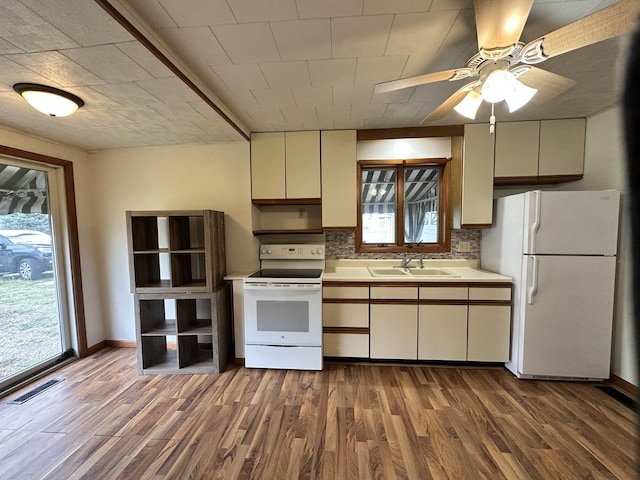 503 N William St, Farmer City, IL 61842 - kitchen featuring backsplash, wood finished floors, a sink, light countertops, and white appliances