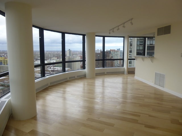 spare room with visible vents, a city view, light wood-style flooring, and track lighting