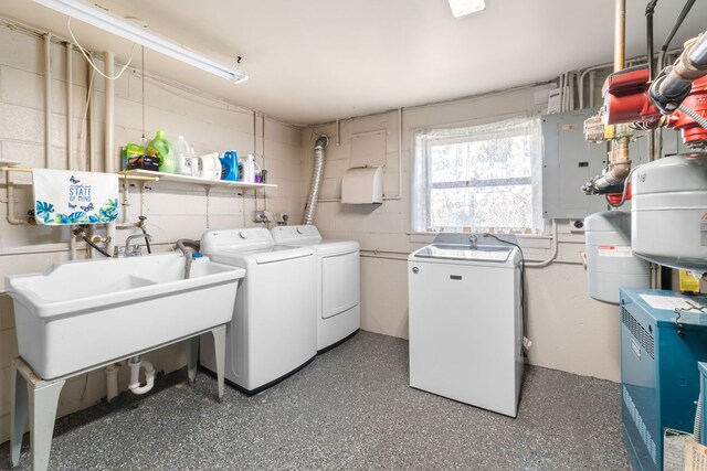 laundry area featuring a heating unit, electric panel, a sink, independent washer and dryer, and concrete block wall