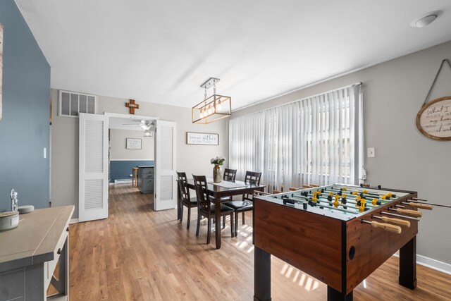 rec room with visible vents, a ceiling fan, baseboards, and light wood-type flooring