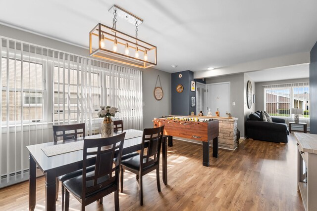 dining area with wood finished floors and a baseboard heating unit