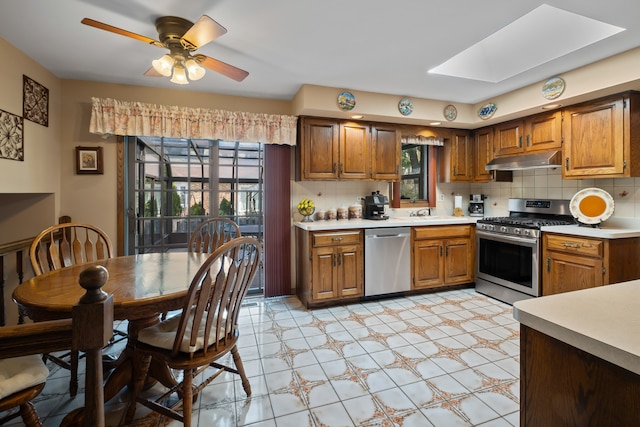 6338 Parkwood Ct, Oak Forest, IL 60452 - kitchen with appliances with stainless steel finishes, under cabinet range hood, light countertops, and a skylight