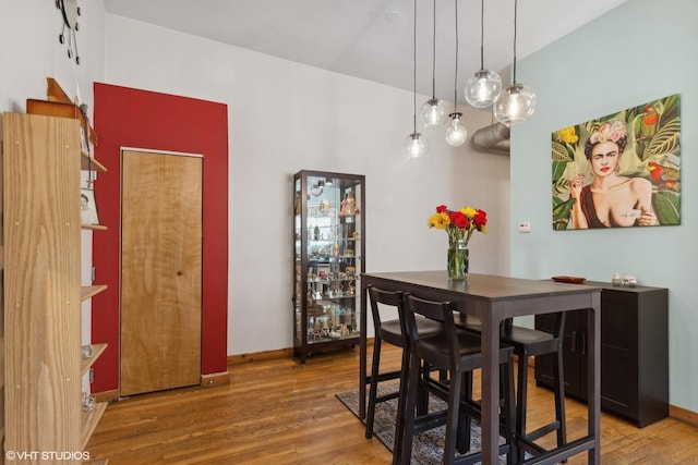 dining space featuring baseboards and wood finished floors