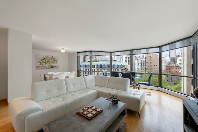 living area with a view of city, a wall of windows, and wood finished floors