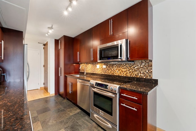 kitchen featuring a sink, dark stone counters, backsplash, and stainless steel appliances