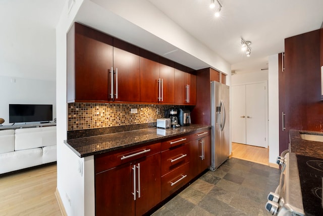 kitchen with backsplash, appliances with stainless steel finishes, a sink, track lighting, and open floor plan