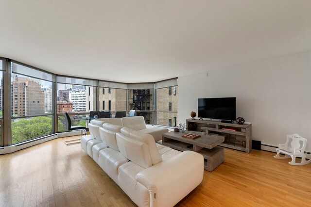 living room featuring a view of city, a wall of windows, and light wood finished floors
