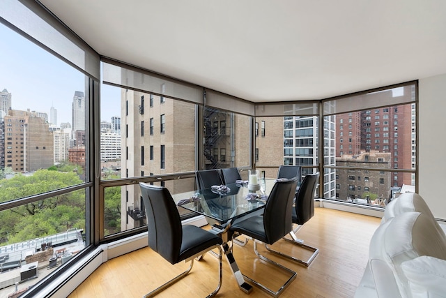 dining space with a city view, wood finished floors, and a wealth of natural light