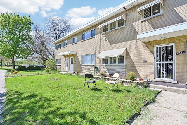 7303 N Campbell Ave Unit A, Chicago, IL 60645 - view of front of house featuring a front yard, brick siding, and entry steps