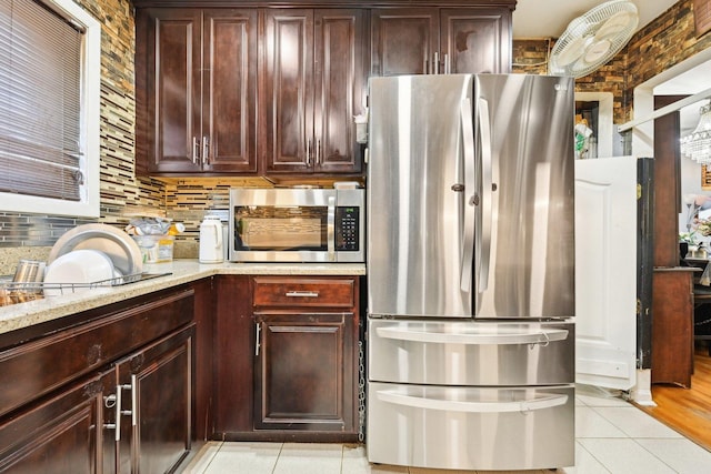 7303 N Campbell Ave Unit A, Chicago, IL 60645 - kitchen featuring stainless steel appliances, light tile patterned flooring, decorative backsplash, light stone countertops, and dark brown cabinetry