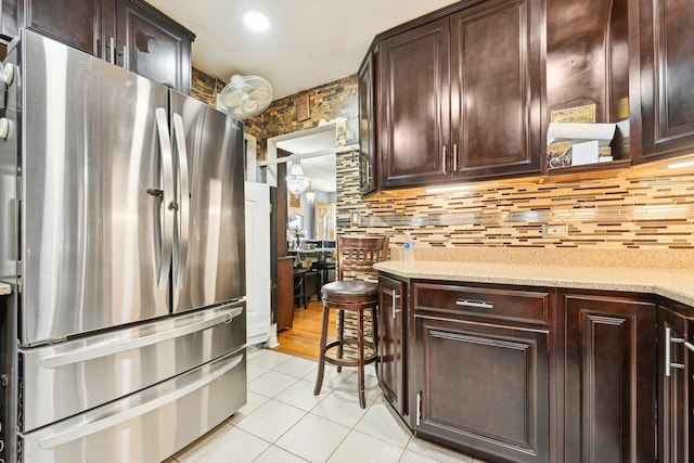 7303 N Campbell Ave Unit A, Chicago, IL 60645 - kitchen with freestanding refrigerator, light tile patterned floors, dark brown cabinets, and tasteful backsplash